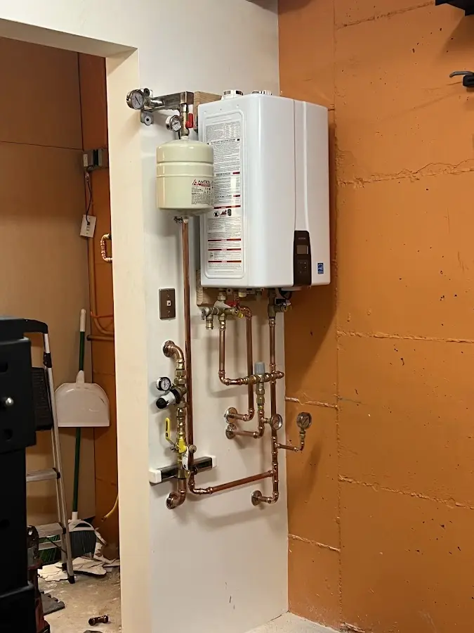 Plumbing technician inspecting water heater connections in Van
